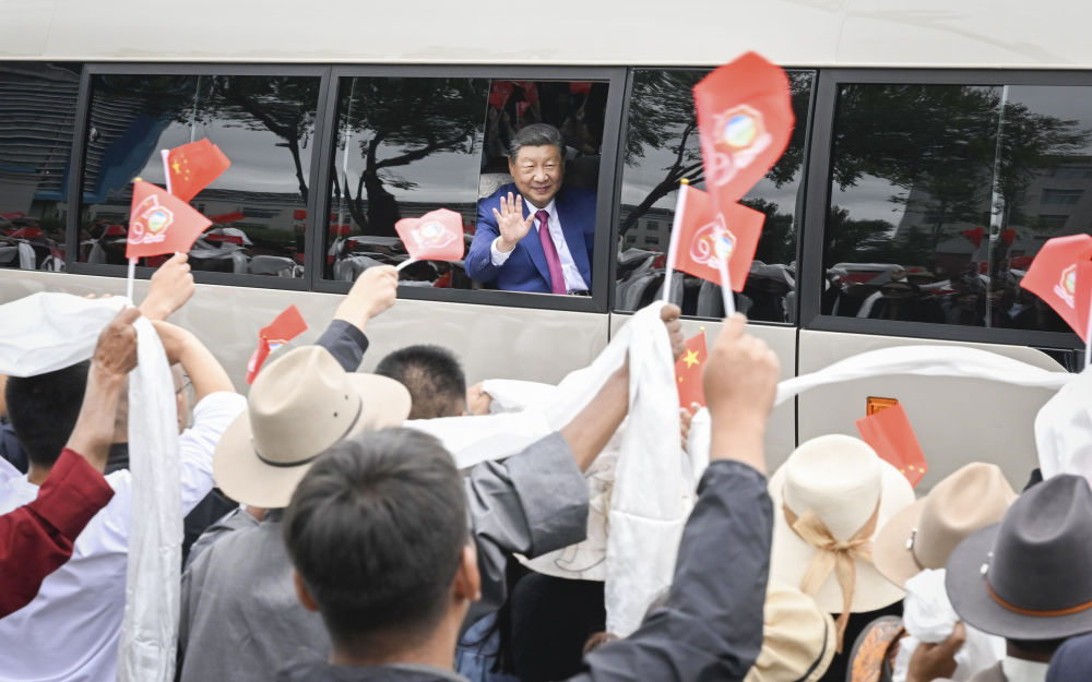 这是习近平打开车窗，向沿途群众频频挥手致意。.jpg